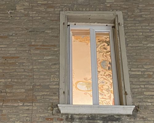 Finestra illuminata con in vista affreschi sul soffitto